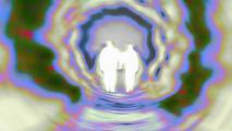 Two people walking through a tunnel.