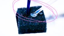 A small piece of black foam with a pink circle around it.