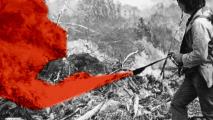 An old black and white photo of a man with a red smoke grenade.