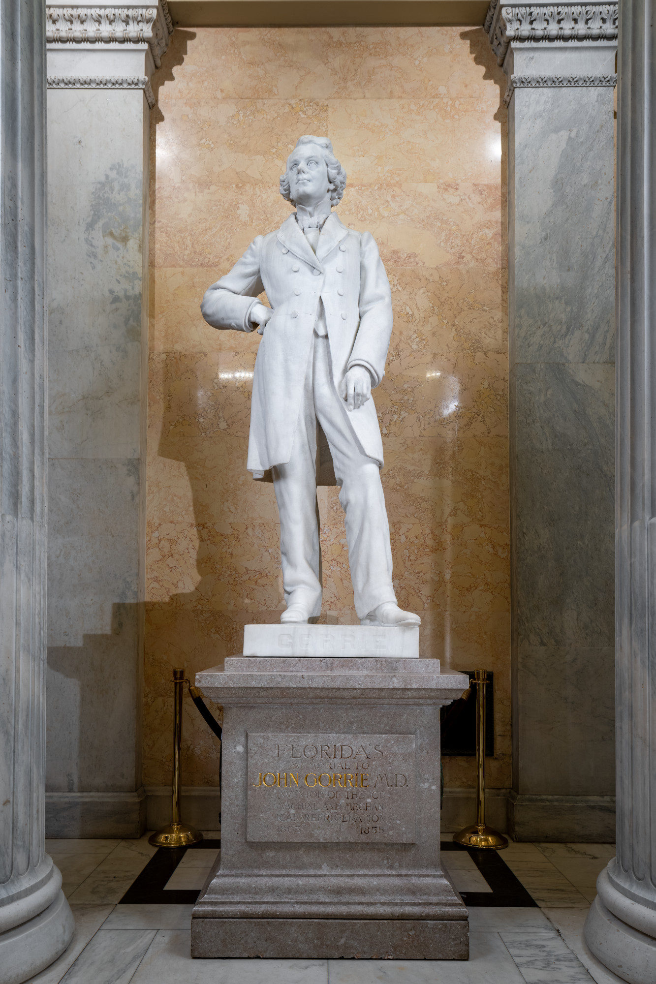a statue of a man on a pedestal in a museum setting