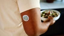 a circular device about the size of a half-dollar stuck on the back of a person's upper arm